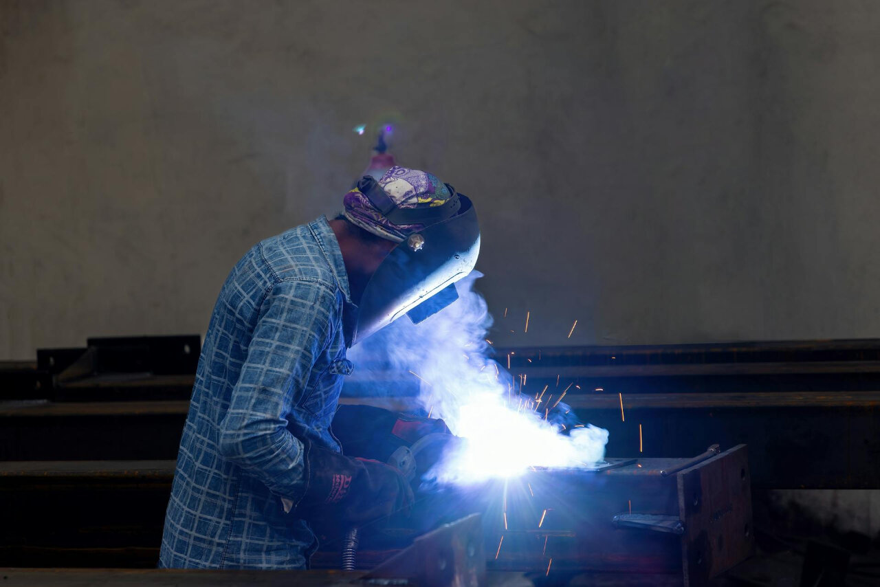 welder working on a metal work piece using the stud welding technique